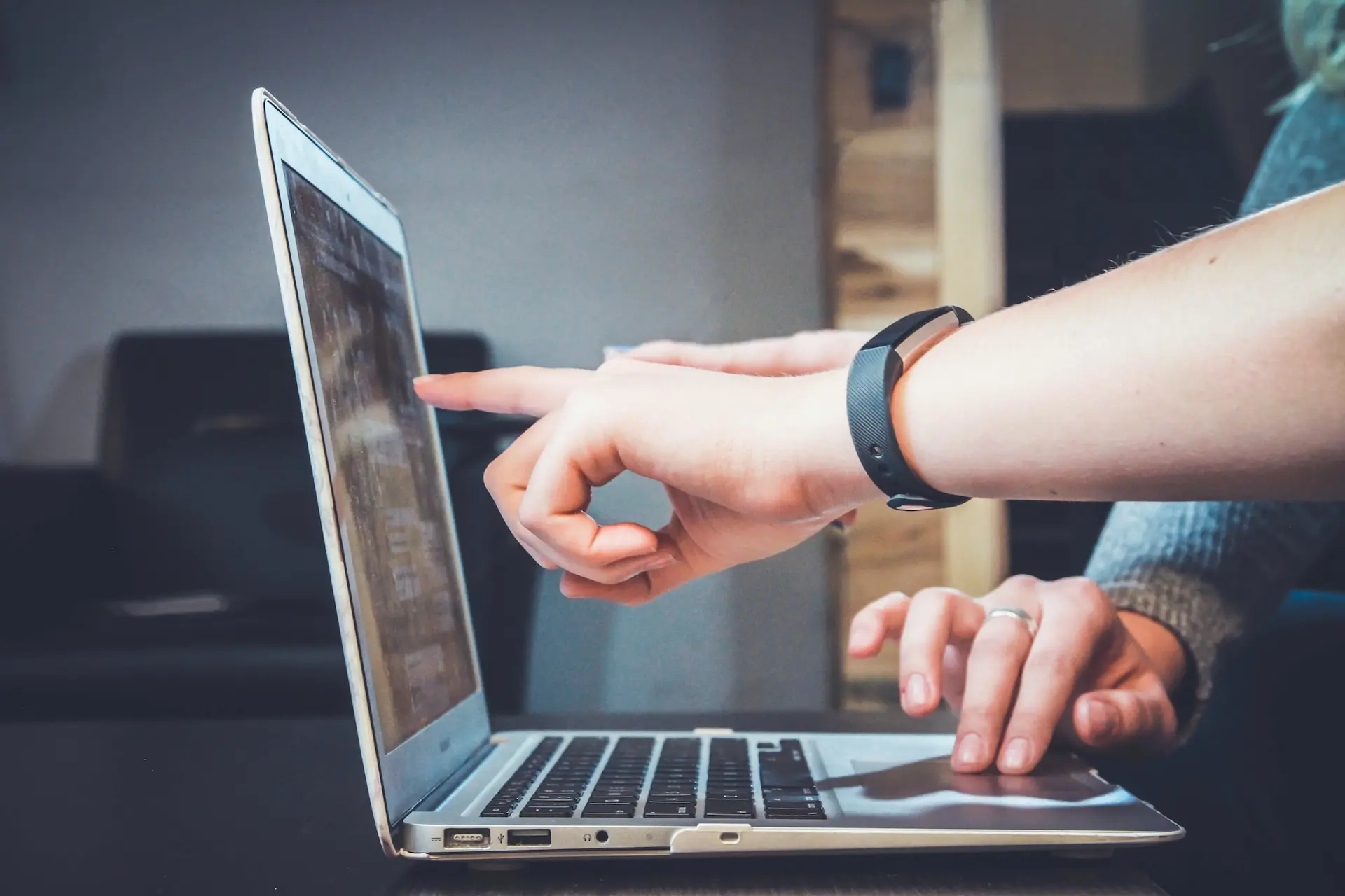 Hand pointing at a screen evaluating someone's work